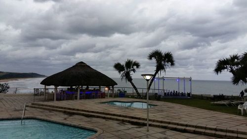 Beach huts by sea against sky