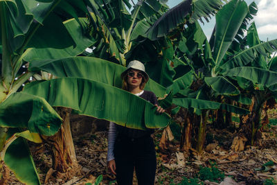 Portrait of smiling young woman standing on leaves