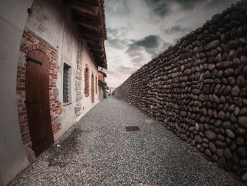 Footpath amidst buildings against sky