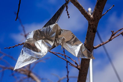 Low angle view of clothes hanging on rope against blue sky