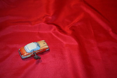 High angle view of red telephone on bed