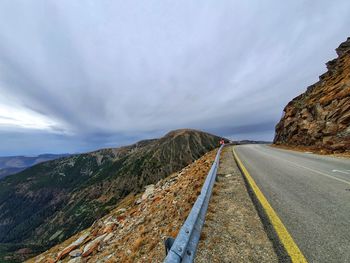 Road by mountain against sky