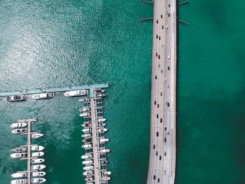 Aerial view of boats moored on sea by bridge 