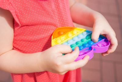 Close-up of girl holding multi colored toy