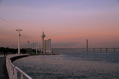 Bridge over sea against sky during sunset