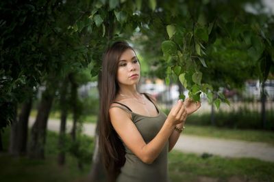 Young woman holding tree leaves