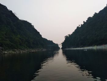 Scenic view of lake by mountains against clear sky