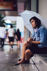 Low section of woman with umbrella