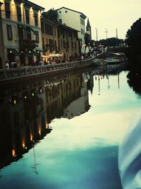 Reflection of buildings in lake against sky in city