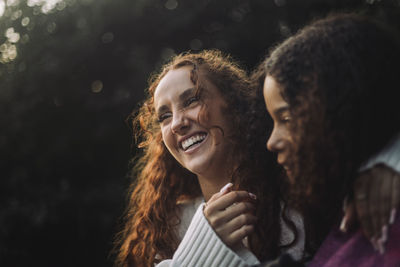 Cheerful girl laughing with female friend