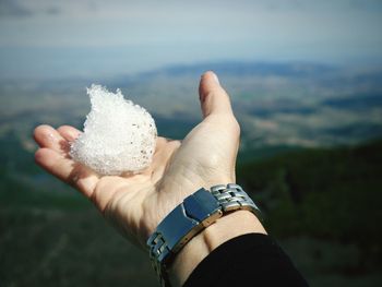 Close-up of human hand holding ice outdoors