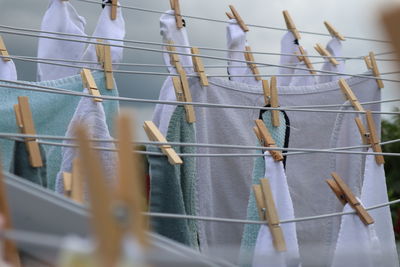 Low angle view of clothes hanging on fence against sky