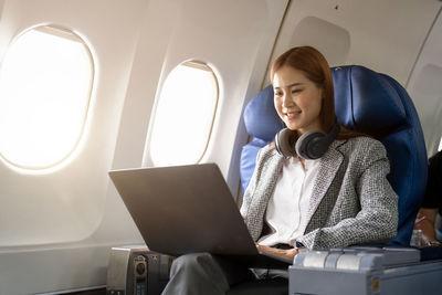 Young woman using laptop while sitting in car