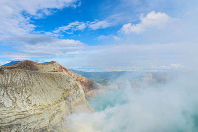 Smoke emitting from volcanic mountain against sky