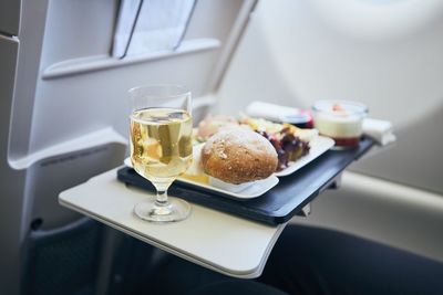 Airline meal and beverage served on seat tables during flight.