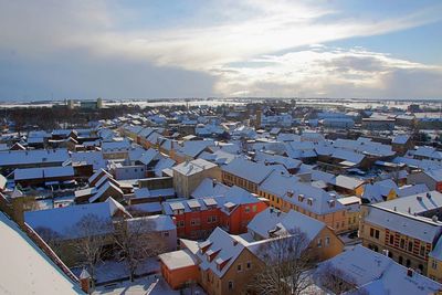 Aerial view of houses in town against sky during winter