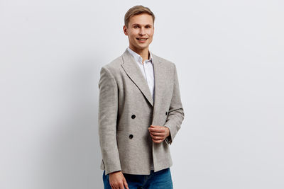 Portrait of businessman standing against white background