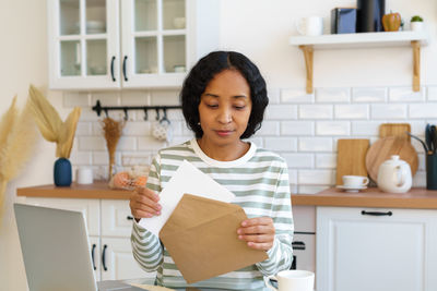 Portrait of smiling young woman standing in creative office