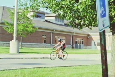 bicycle, transportation, land vehicle, mode of transport, building exterior, riding, architecture, built structure, street, cycling, tree, road, full length, stationary, parked, parking, side view, grass