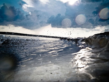 Surface level of wet shore against sky