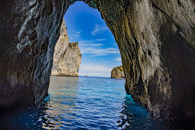 Panoramic view of rock formation in sea against sky