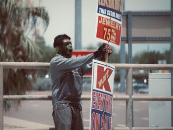 Rear view of man with text standing on sign