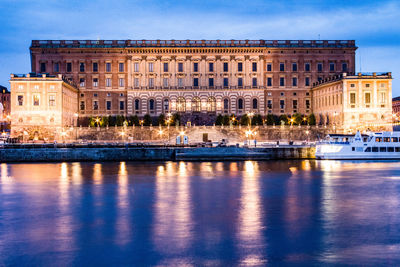 Illuminated palace by river in told town at dusk