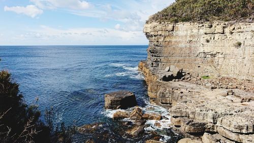 Scenic view of rocks on beach against sky