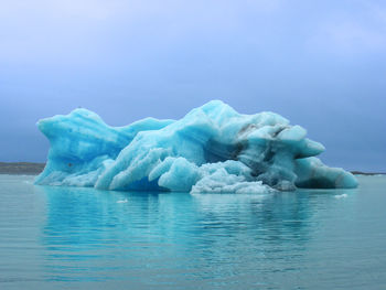 Ice floating on sea against sky