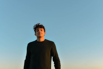 Low angle view of man standing against clear sky