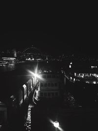 Man and illuminated ferris wheel against sky at night