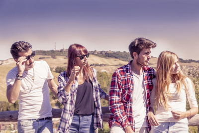 Friends standing against sky