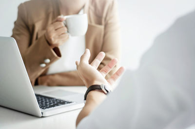 Midsection of woman using laptop