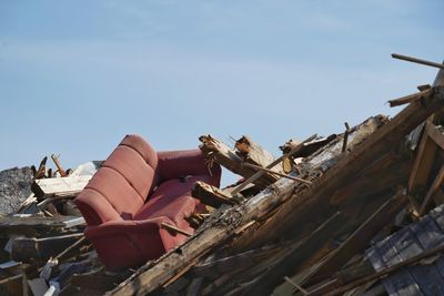 Abandoned boat on roof against sky