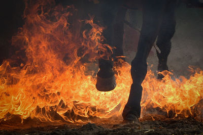 Low section of man standing against bonfire