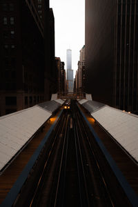 Railroad tracks in city against sky