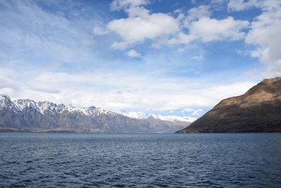 Scenic view of sea and mountains against sky