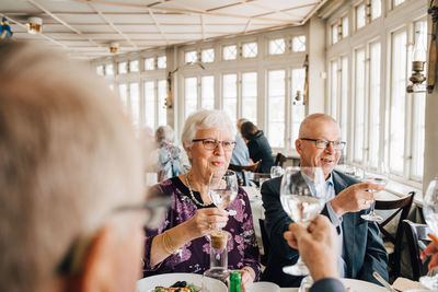 Senior friends with wineglass toasting in restaurant