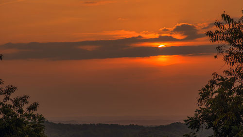 Scenic view of silhouette landscape against orange sky