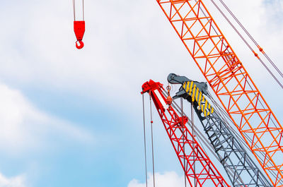 Crawler crane against blue sky and white clouds. real estate industry. red crawler crane.