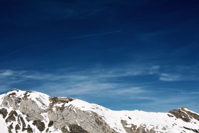 Scenic view of snowcapped mountains against blue sky