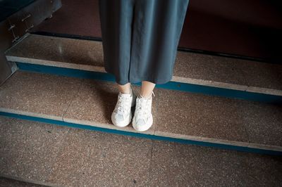Low section of woman standing on staircase