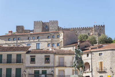 Buildings in city against clear blue sky