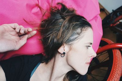 Close-up portrait of woman with pink background and bmx bike