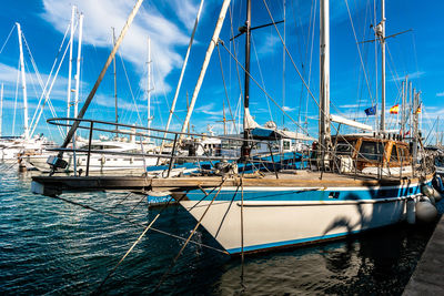 Sailboats moored in sea against sky