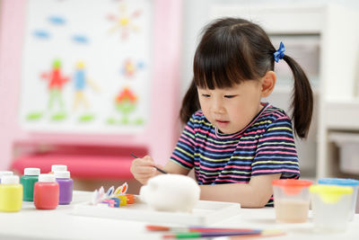 Cute girl learning painting at school