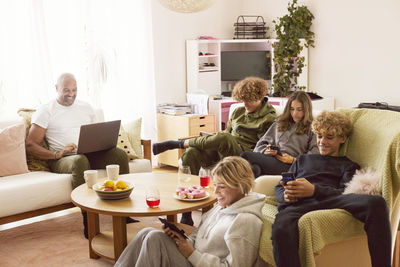 Family with children using electronic devices at home