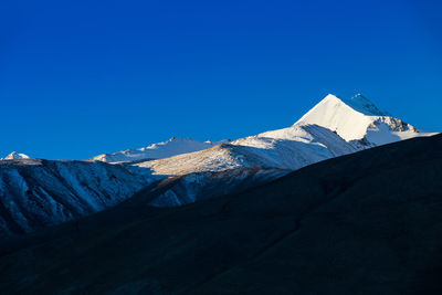 Scenic view of snowcapped mountains against clear blue sky