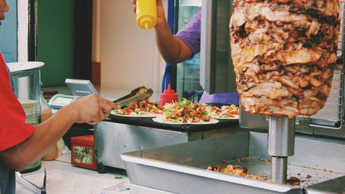 Close-up of men preparing food at market