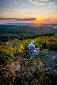 Man looking at mountains against sky during sunset